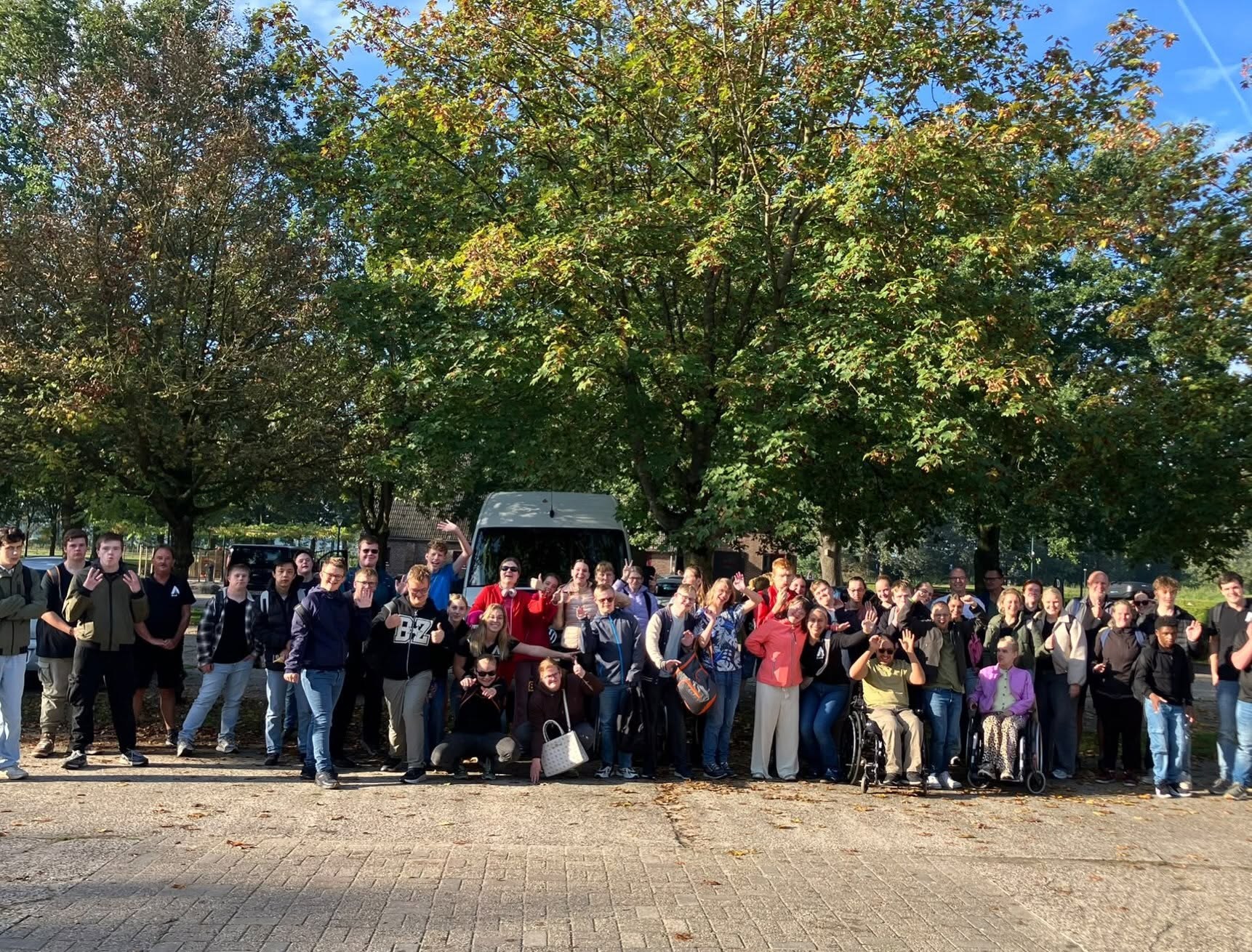 De groep van Het Ambacht samen op de foto bij de busjes.