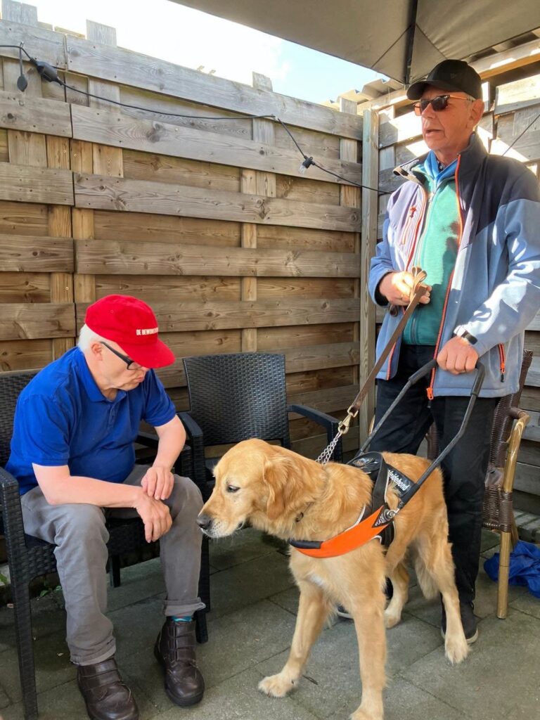 Bezoek met een blindengeleidehond op het terras van Het Ambacht.