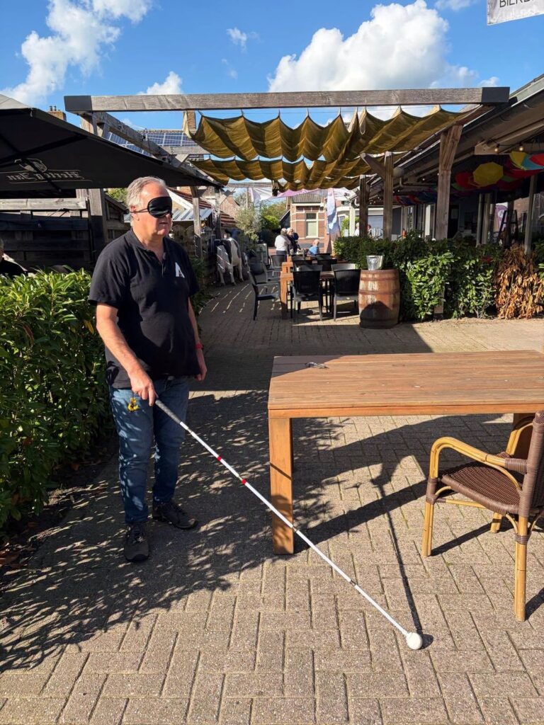 Zelf ervaren hoe het is om met een blinddoek en taststok te lopen.
