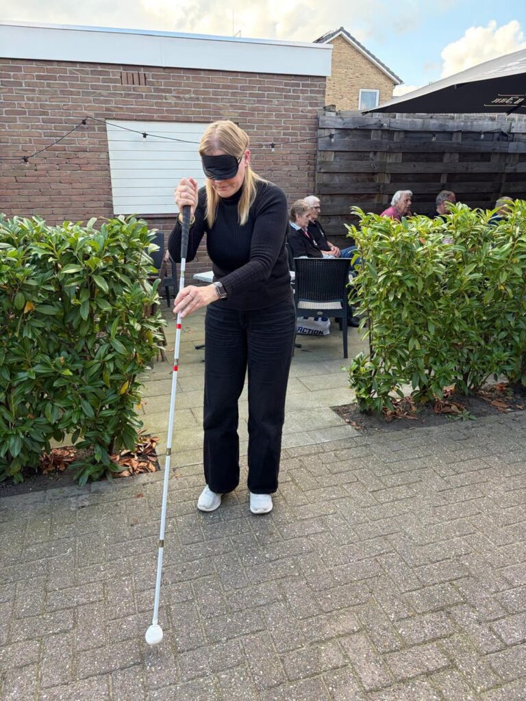 Zelf ervaren hoe het is om met een blinddoek en taststok te lopen.